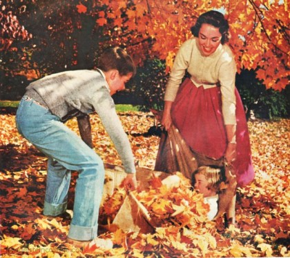 mid century family playing in fall leaves
